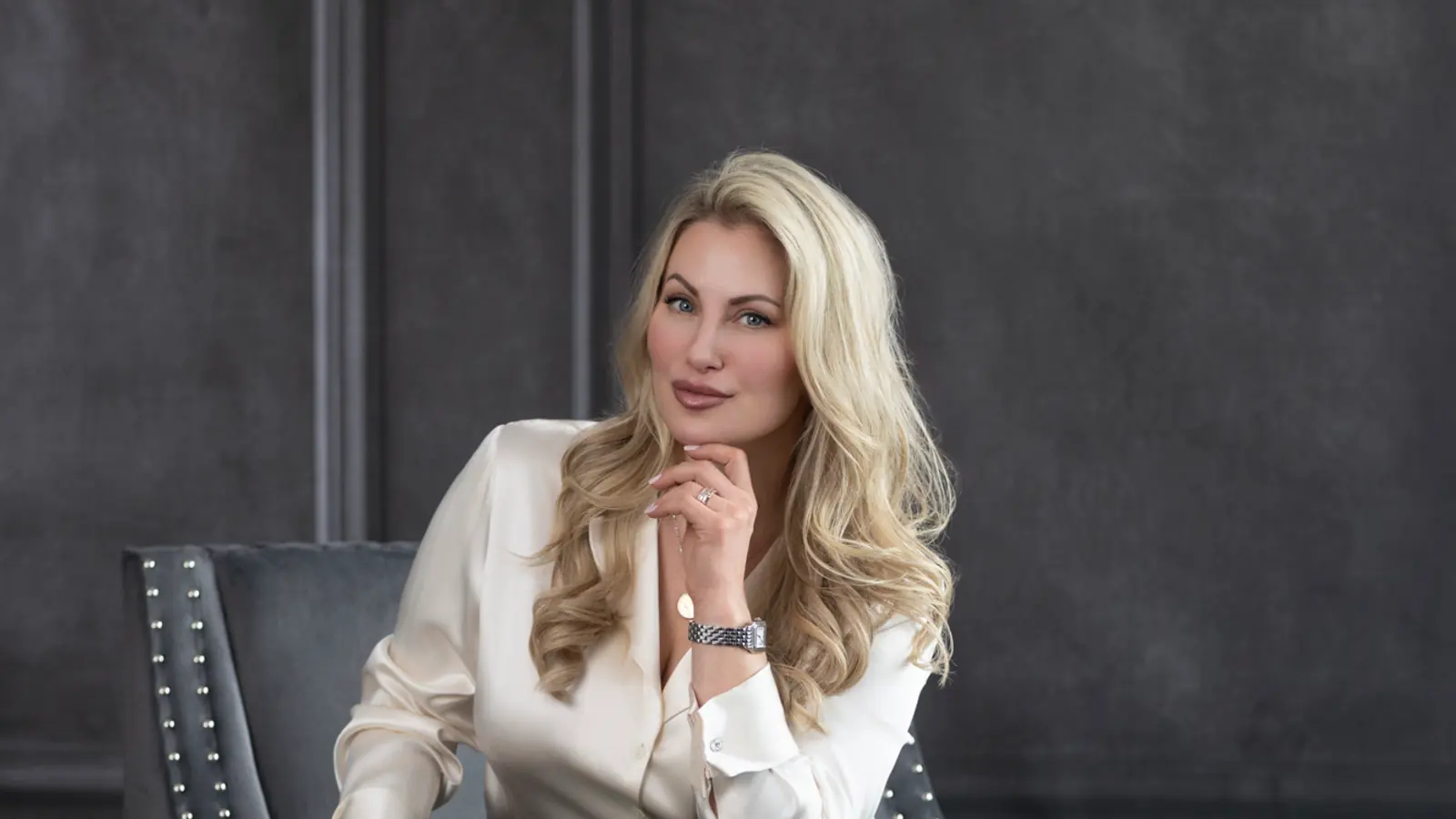 Professional headshot of a seated woman photographed with soft directional studio light